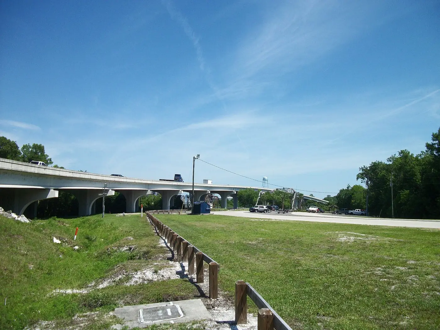 Two bridges over Lake Monroe seen from a grassy park