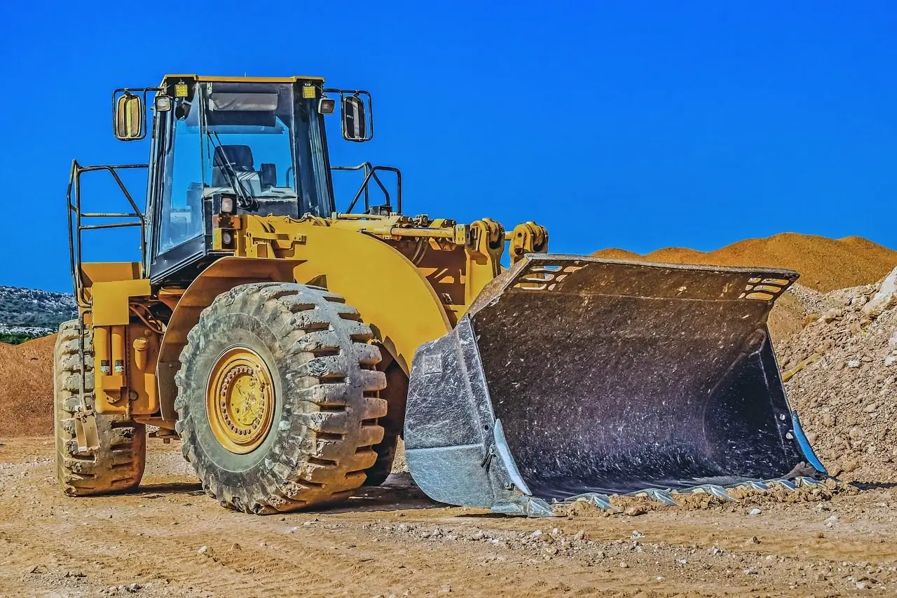 Yellow wheel loader in front of a dirt pile